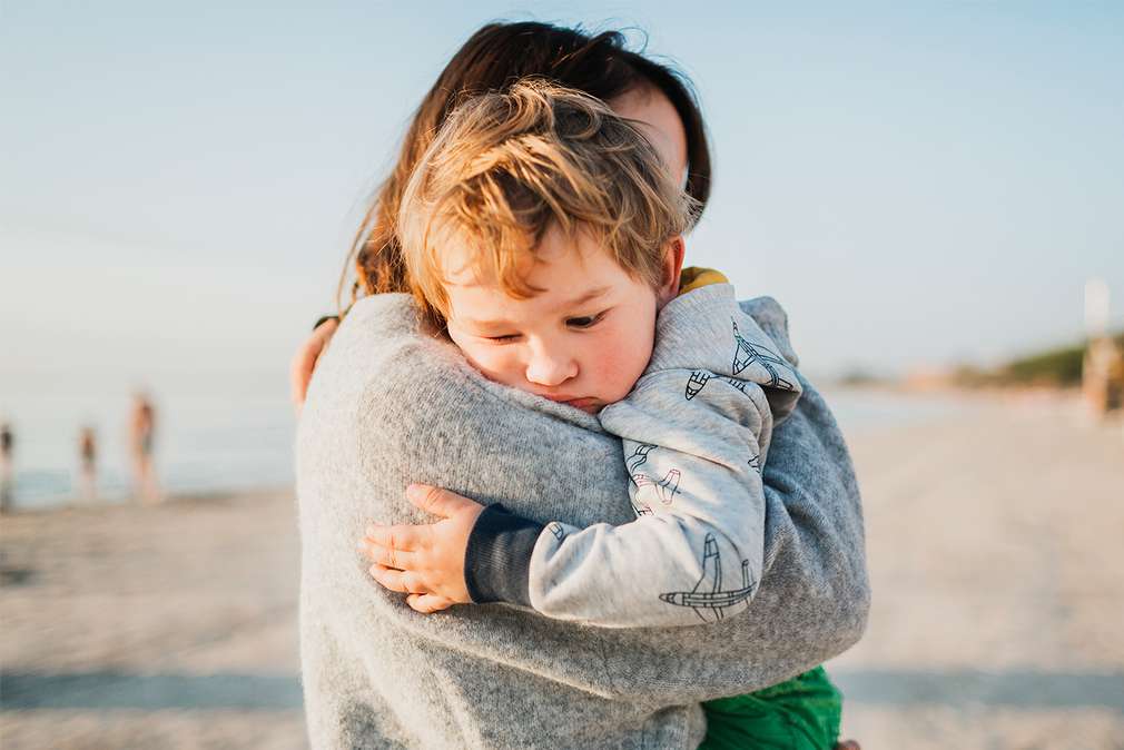 Изображение на майка, която прегръща и успокоява своето малко момченце