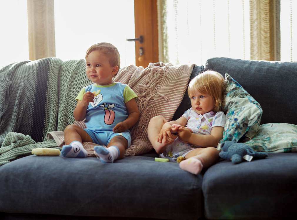 Изображение на две малки деца, седнали на диван. Богат асортимент Kuniboo®
