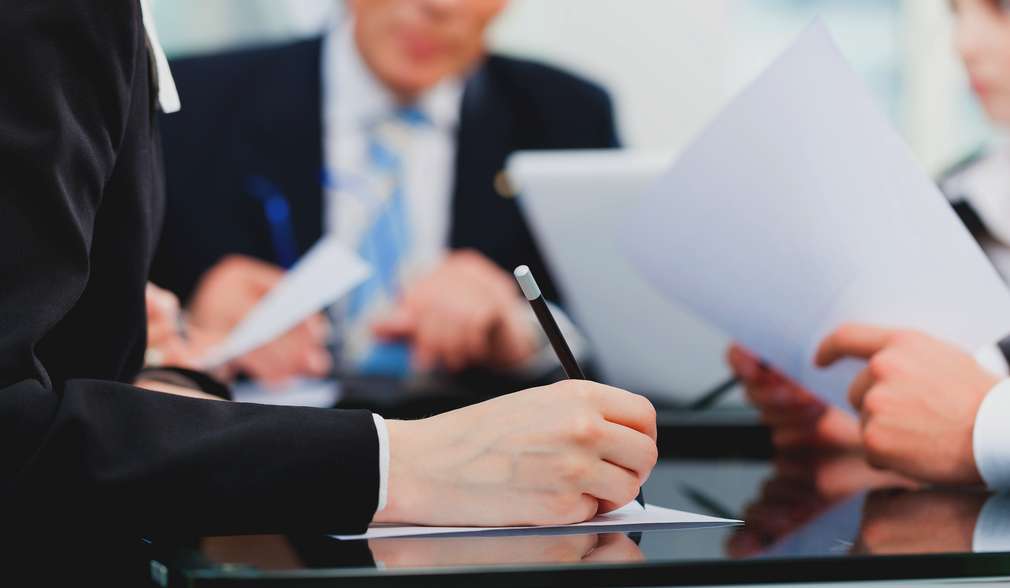 Compliance ръка подписва документи с писалка