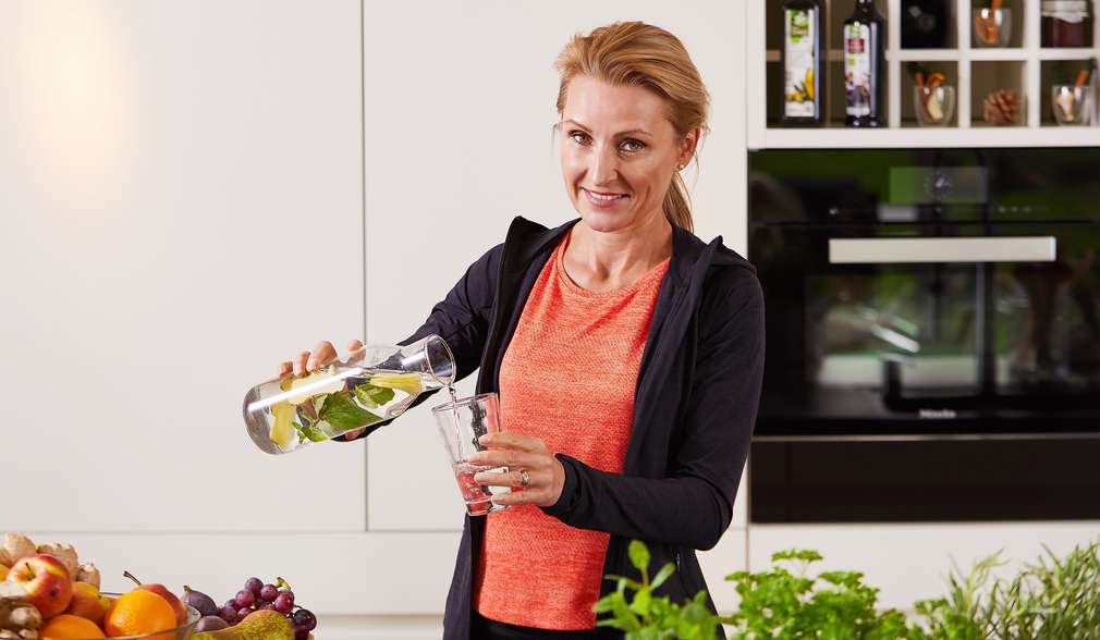 Ernährungswissenschaftlerin Alexa Iwan mit Glaskaraffe in der Hand Ernährungswissenschaftlerin Alexa Iwan mit Glaskaraffe in der Hand