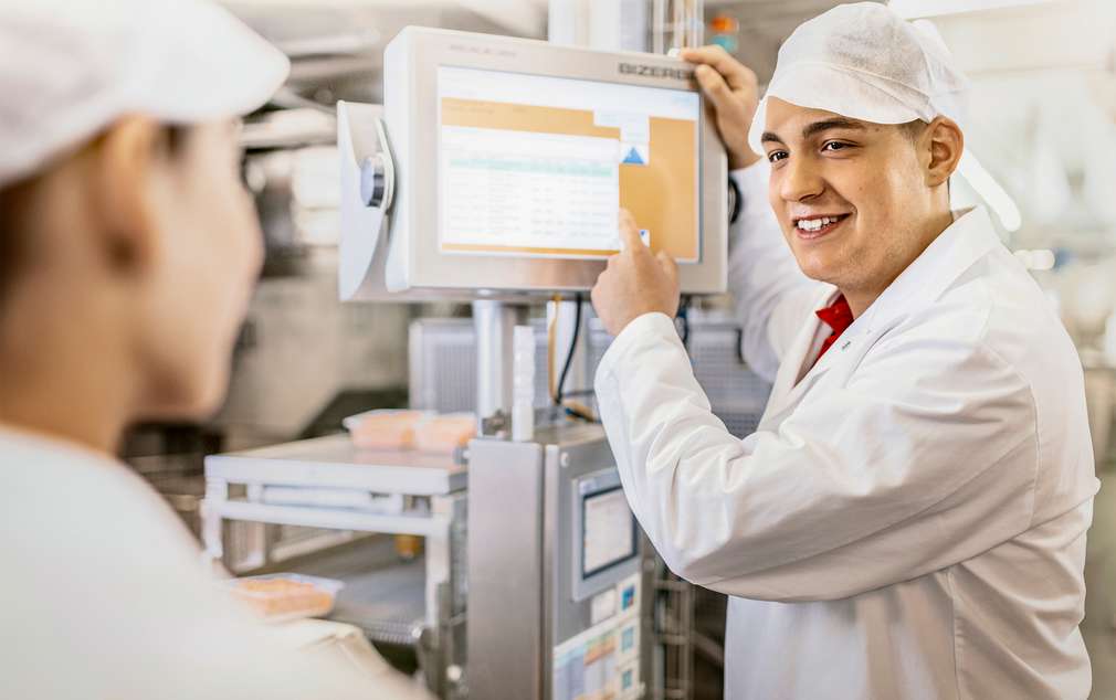 Mitarbeiter im Gespräch an der Produktionslinie Mitarbeiter im Gespräch an der Produktionslinie