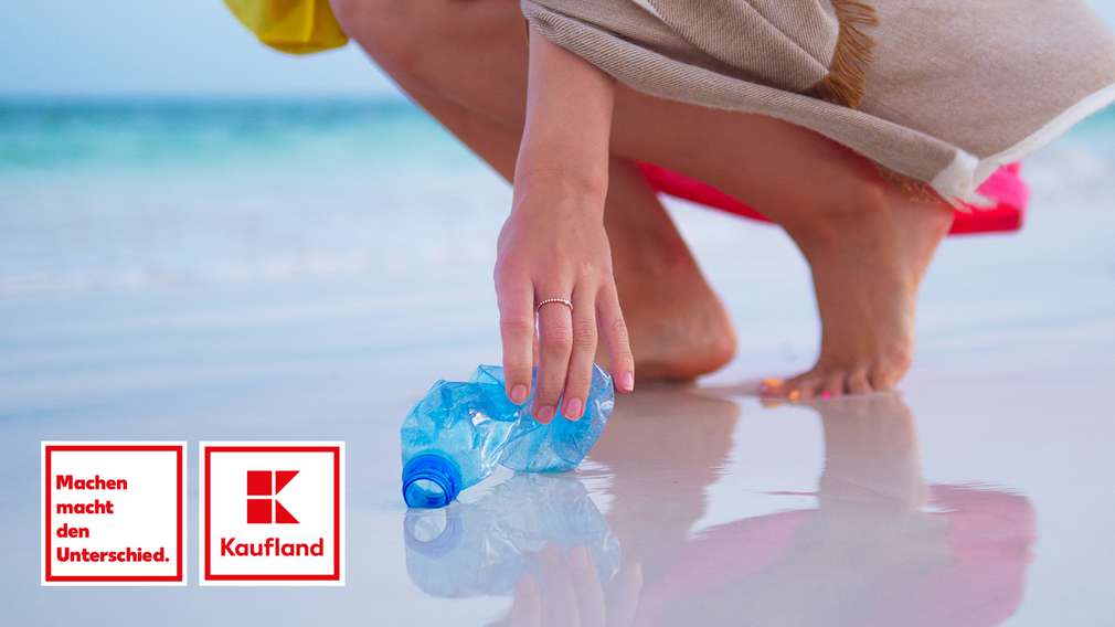 Frau am Strand sammelt leere PET-Flasche Frau am Strand sammelt leere PET-Flasche