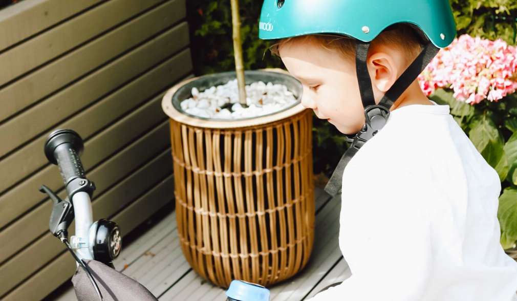 Kind mit einem Helm inspiziert ein Fahrrad Kind mit einem Helm inspiziert ein Fahrrad