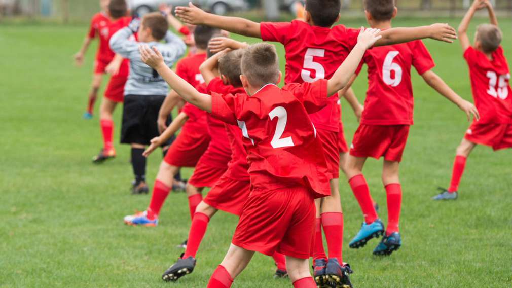 Kinder im Fußballtrikot auf Spielfeld Kinder im Fußballtrikot auf Spielfeld