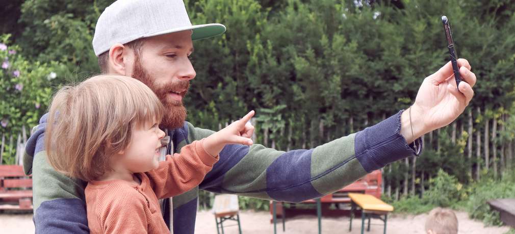 Vater macht mit Sohn ein Selfie mit dem Smartphone