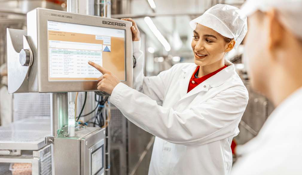 Auszubildender bespricht mit einer Kollegin ein neues Fleischprodukt Auszubildender bespricht mit einer Kollegin ein neues Fleischprodukt