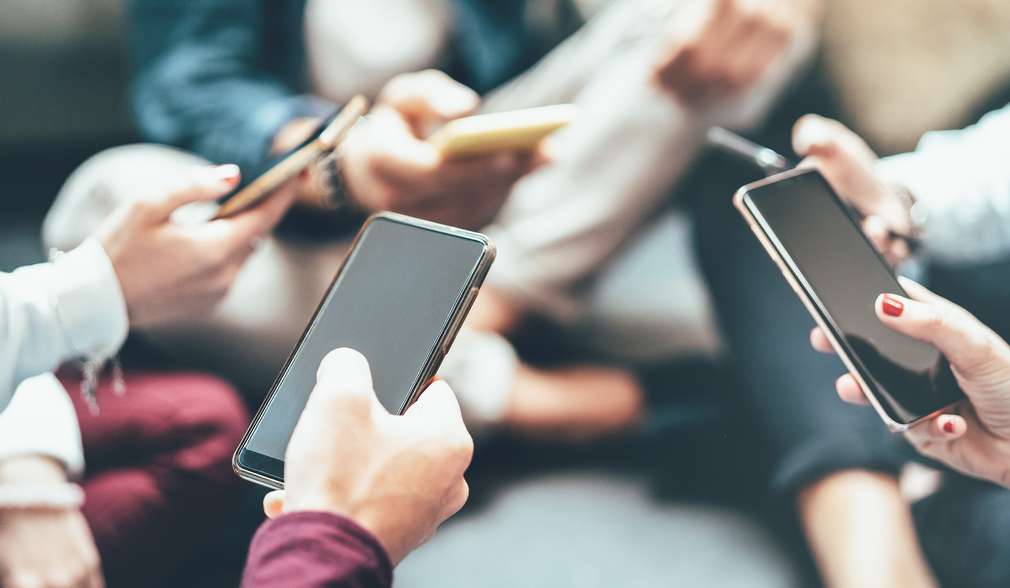 Mehrere Personen, die ein Smartphone in der Hand halten Mehrere Personen, die ein Smartphone in der Hand halten