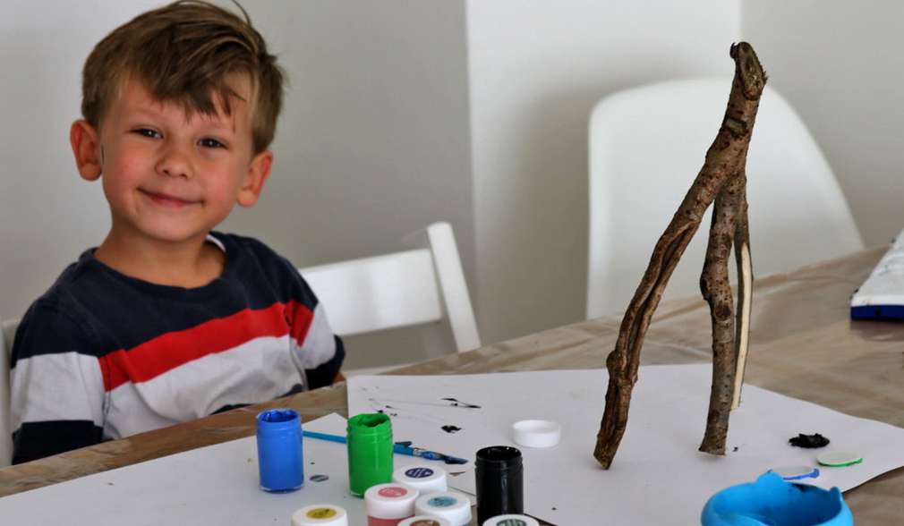 Kleiner Junge zusammen mit seinem selbstgebastelten Waldgeist aus Äste Kleiner Junge zusammen mit seinem selbstgebastelten Waldgeist aus Äste