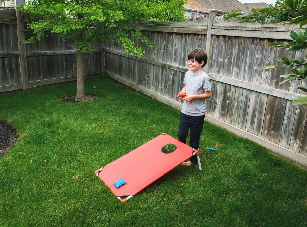 Junge im Garten beim Zielwerfen Junge im Garten beim Zielwerfen