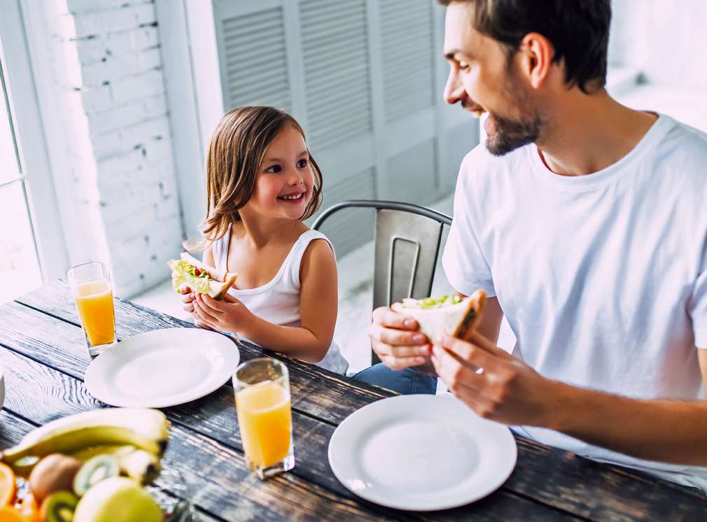 Vater und Tochter essen gemeinsam am Tisch Vater und Tochter essen gemeinsam am Tisch