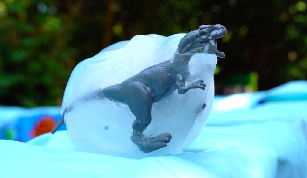 Spielzeugdinosaurier in einem Eisblock eingefroren Spielzeugdinosaurier in einem Eisblock eingefroren