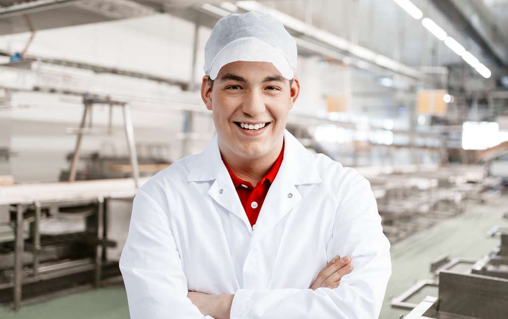 Portrait von Auszubildendem in der Produktionshalle des Fleischwerks Portrait von Auszubildendem in der Produktionshalle des Fleischwerks