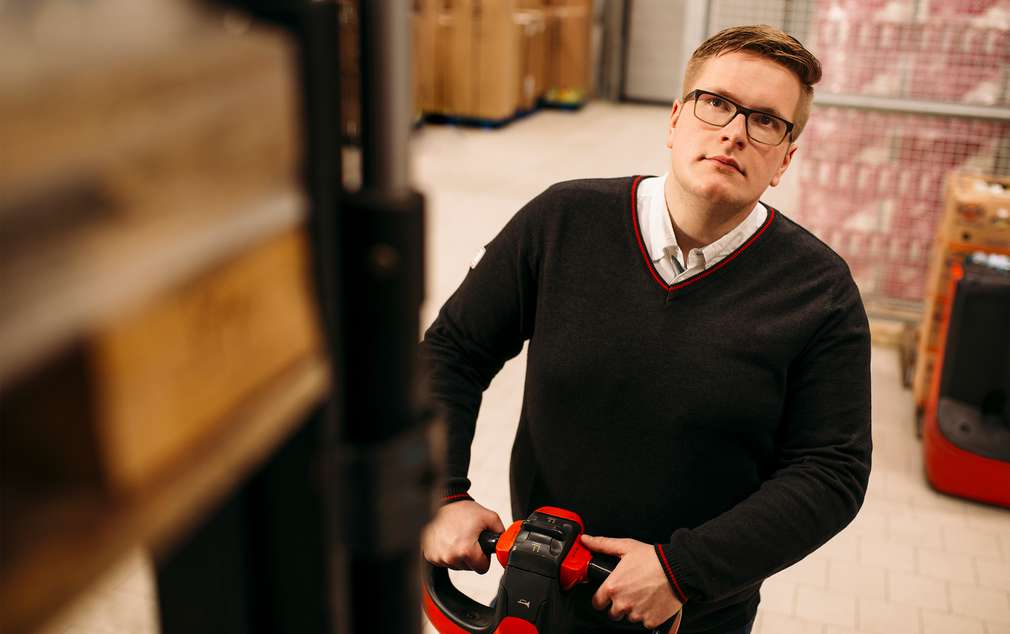 Absolvent des Abiturientenprogramms verräumt Ware im Lager eines Marktes