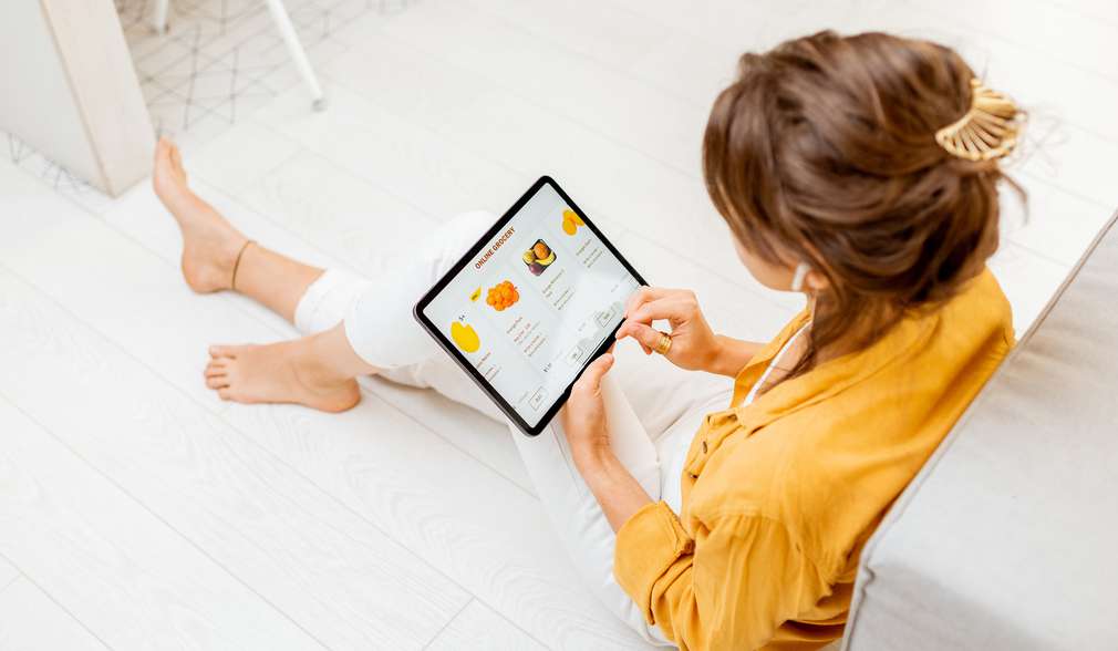 Kundin mit Tablet beim Reservieren Kundin mit Tablet beim Reservieren