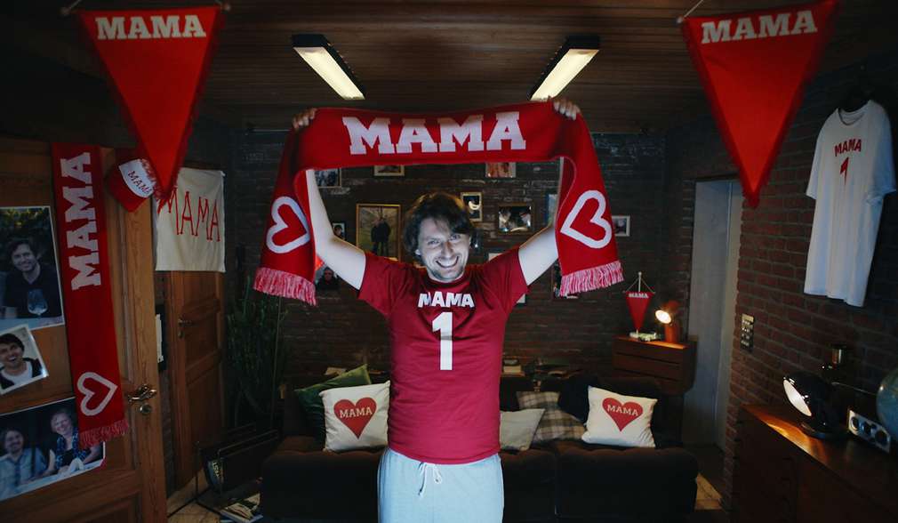 Mann hebt Fan-Schal mit dem Schriftzug „Mama“ hoch Mann hebt Fan-Schal mit dem Schriftzug „Mama“ hoch