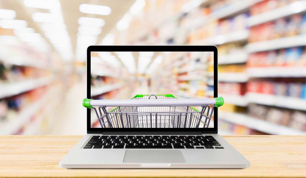 Laptop mit Einkaufwagen im Markt Laptop mit Einkaufwagen im Markt
