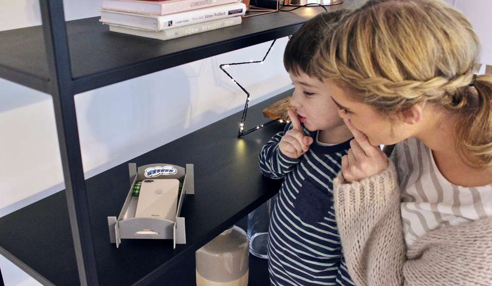 Mutter und Kind legen Smartphone ins Handybett Mutter und Kind legen Smartphone ins Handybett