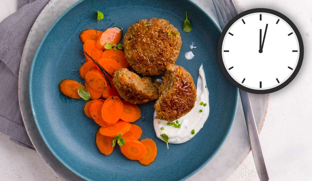 Fleisch-Getreide-Frikadellen mit Vanillemöhren, daneben Uhr Fleisch-Getreide-Frikadellen mit Vanillemöhren, daneben Uhr