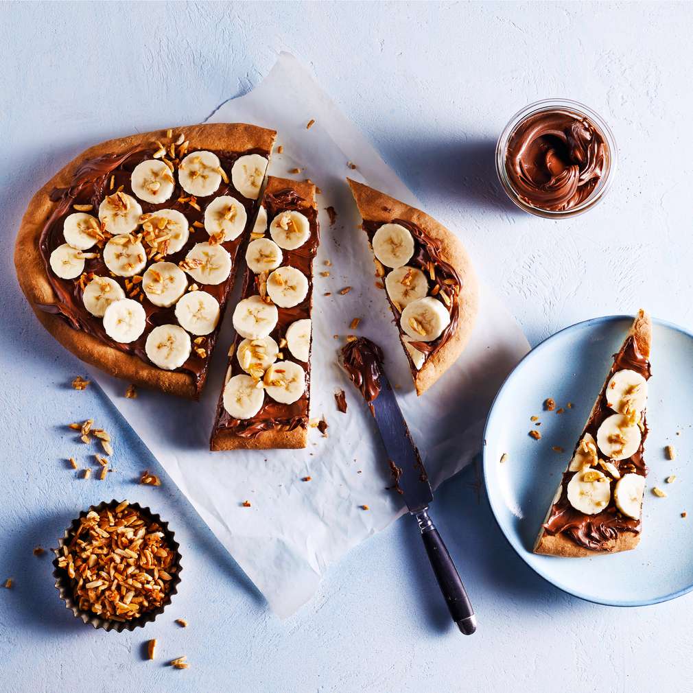 Abbildung des Rezepts Süße Bananenpizza mit karamellisierten Mandeln Abbildung des Rezepts Süße Bananenpizza mit karamellisierten Mandeln
